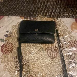 A michael kors bag in the color black.